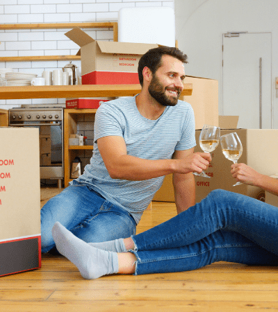 Happy couple celebrating after unpacking boxes with the help of professional movers and packers and a trusted removalist Rockingham.