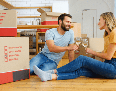 Happy couple celebrating after unpacking boxes with the help of professional movers and packers and a trusted removalist Rockingham.